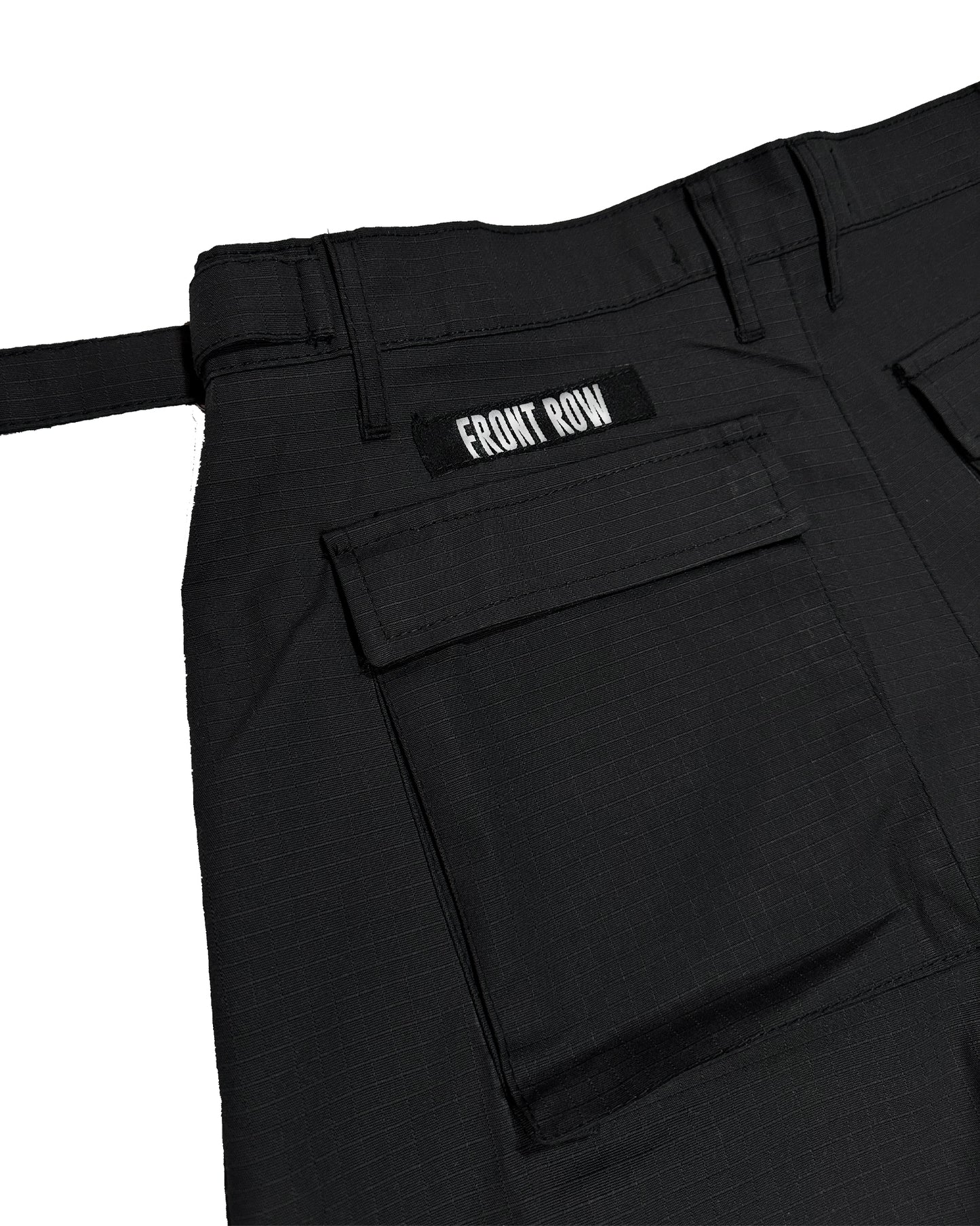 Pantalón cargo negro oversize de ripstop, corte tres cuartos unisex, bolsillos laterales grandes y cinturón ajustable, estilo streetwear/techwear resistente y cómodo.