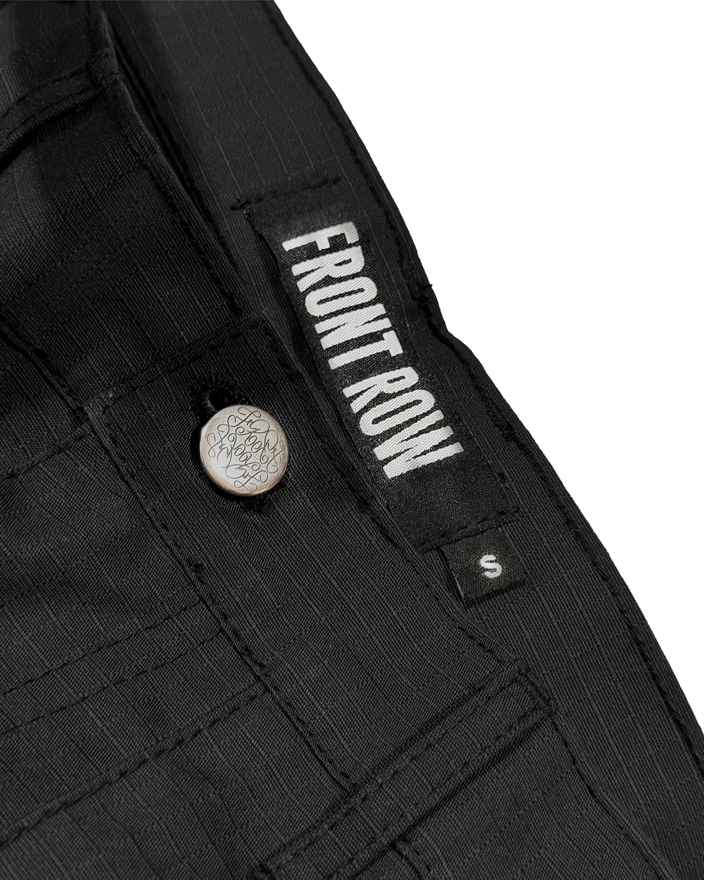 Pantalón cargo negro oversize de ripstop, corte tres cuartos unisex, bolsillos laterales grandes y cinturón ajustable, estilo streetwear/techwear resistente y cómodo.