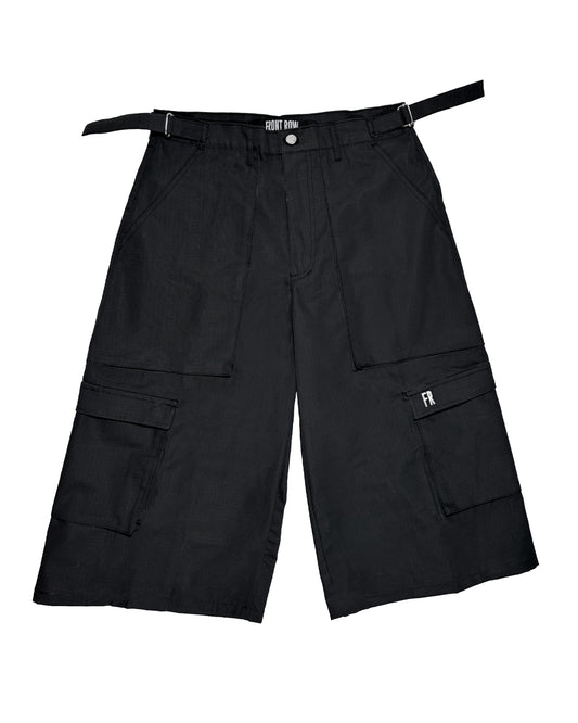 Pantalón cargo negro oversize de ripstop, corte tres cuartos unisex, bolsillos laterales grandes y cinturón ajustable, estilo streetwear/techwear resistente y cómodo.
